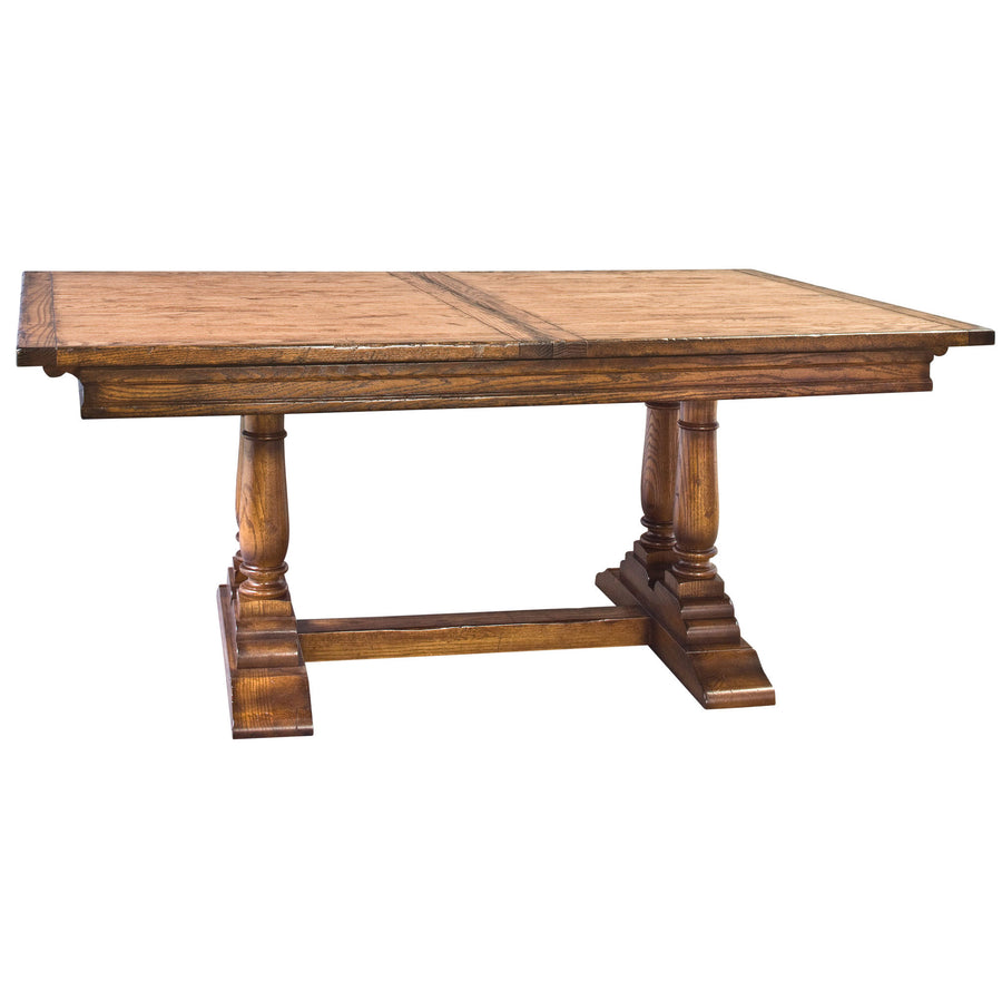 Expandable trestle dining table in oak with a plank top, chunky turned columns and stretcher base