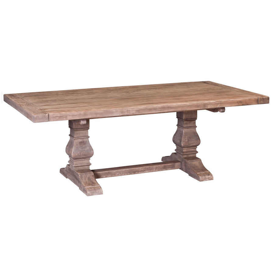 Weathered driftwood gray trestle dining table with a thick plank top and two carved pedestal supports