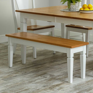 Two-tone dining bench with a natural oak seat and white painted turned legs beside a matching farmhouse table