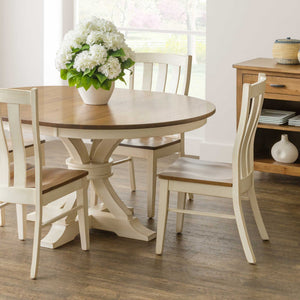 Cream painted Willow lumbar dining chairs with curved slat backs and natural wood seats around a round two-tone pedestal table