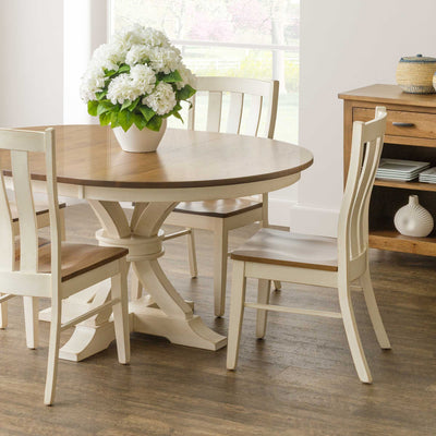 Cream painted Willow lumbar dining chairs with curved slat backs and natural wood seats around a round two-tone pedestal table