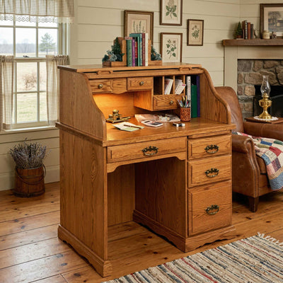 Oak roll top computer desk styled in a farmhouse room with lit interior cubbies, drawers and a stone fireplace behind