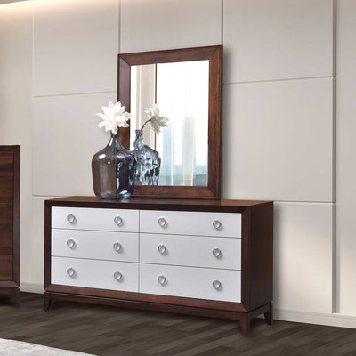 Six drawer dresser with white drawer fronts, cherry case and mirror, styled with glass vases in a modern bedroom