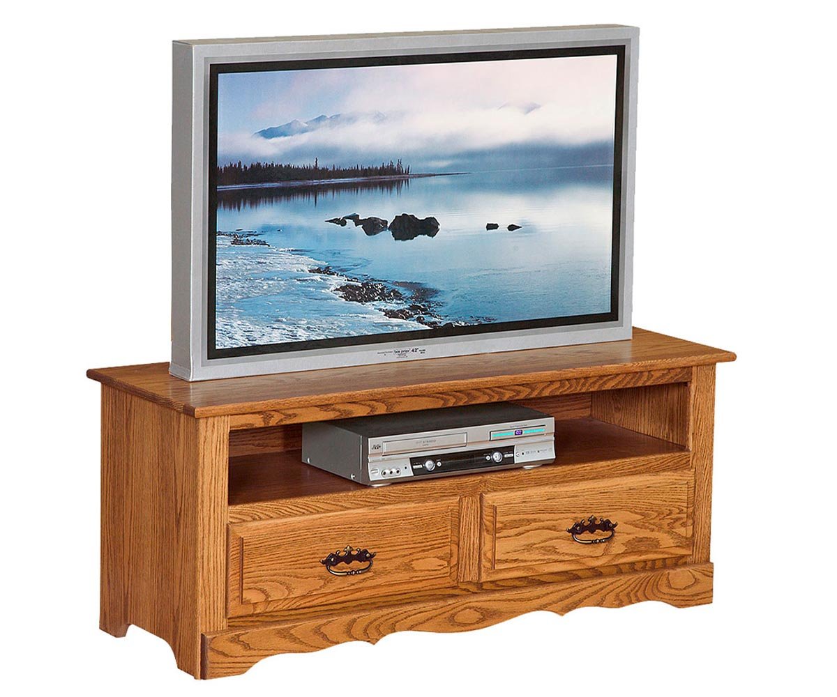 Golden oak TV console with an open media shelf, two drawers with black bail pulls and a curved skirt on a white background
