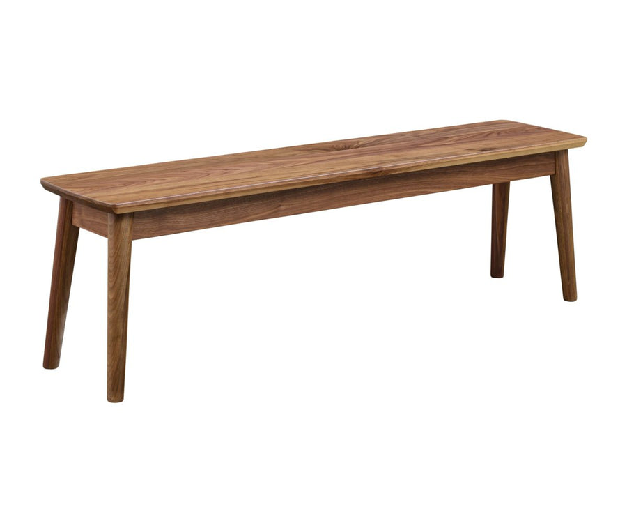 Solid walnut dining bench with softly rounded edges and angled tapered legs on a white background