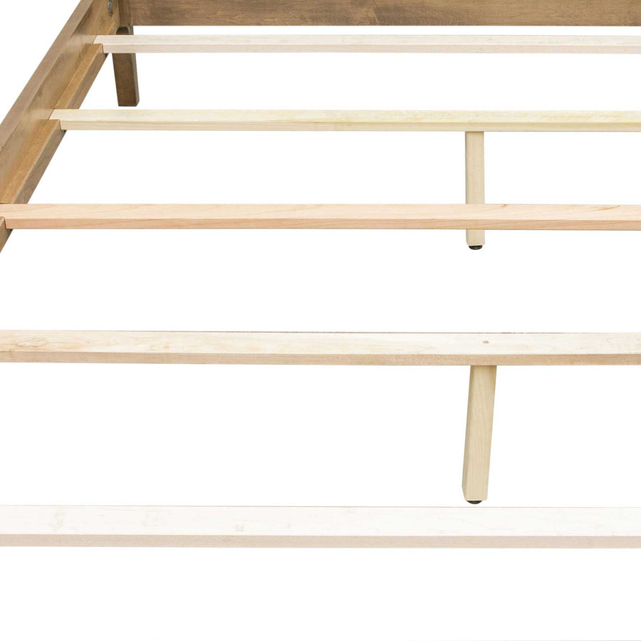 Bed frame underside showing unfinished wooden support slats resting on side rails with a center support leg