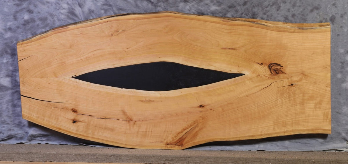Cherry live edge slab 89 inches long and 30 to 40 inches wide with a black epoxy filled center void