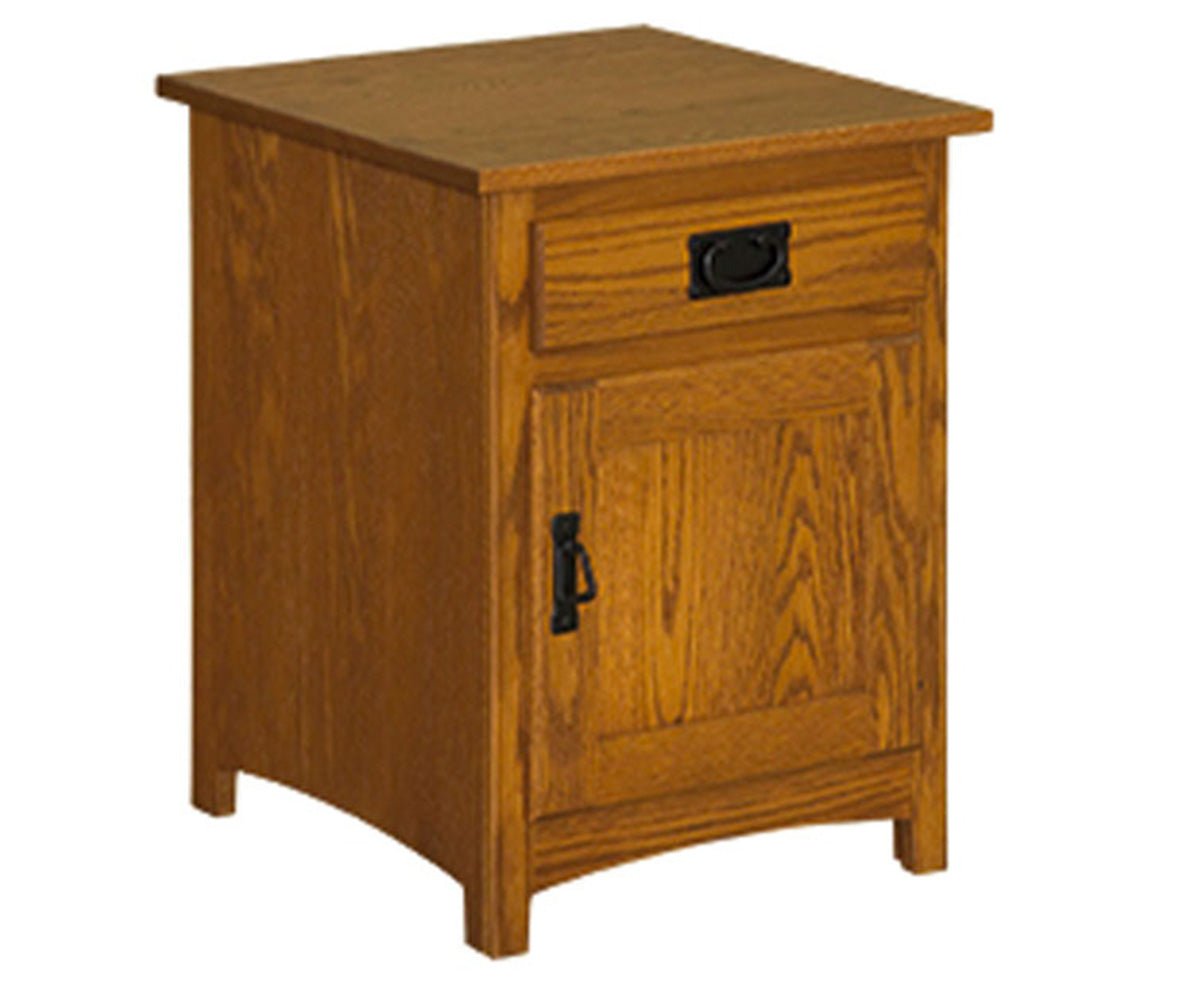 Mission oak end table with a drawer above a paneled door, black bail pull and drop handle on a white background