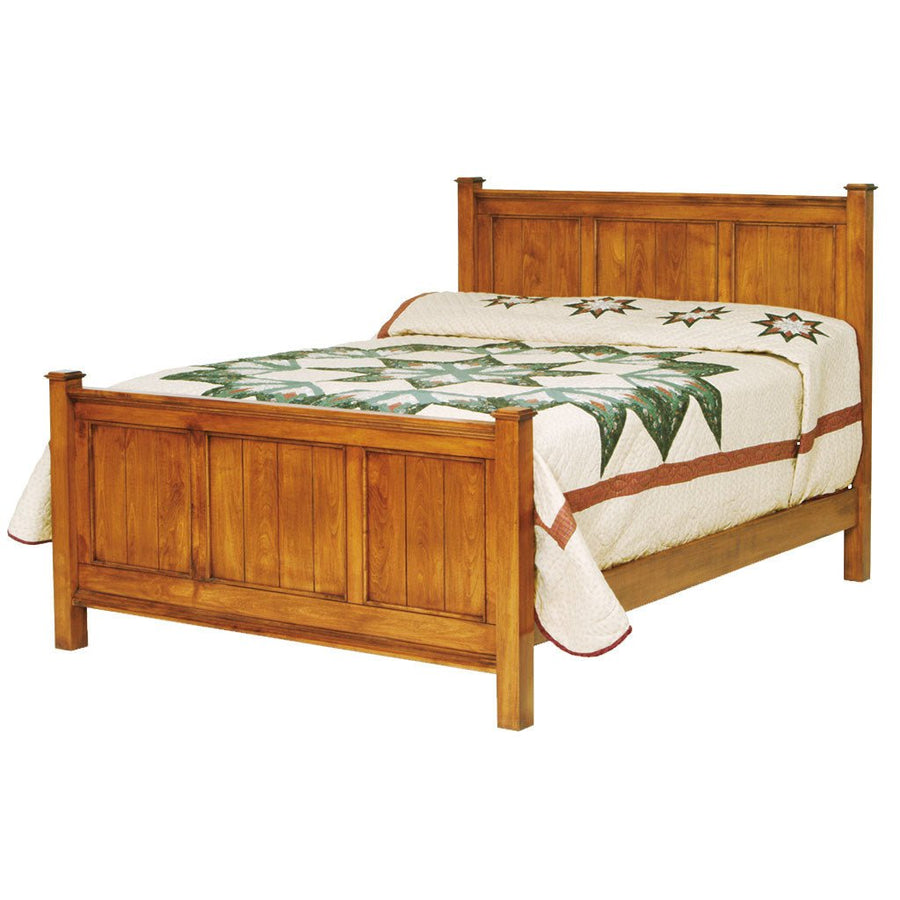 Honey oak panel bed with square posts and paneled headboard and footboard, topped with a green star quilt