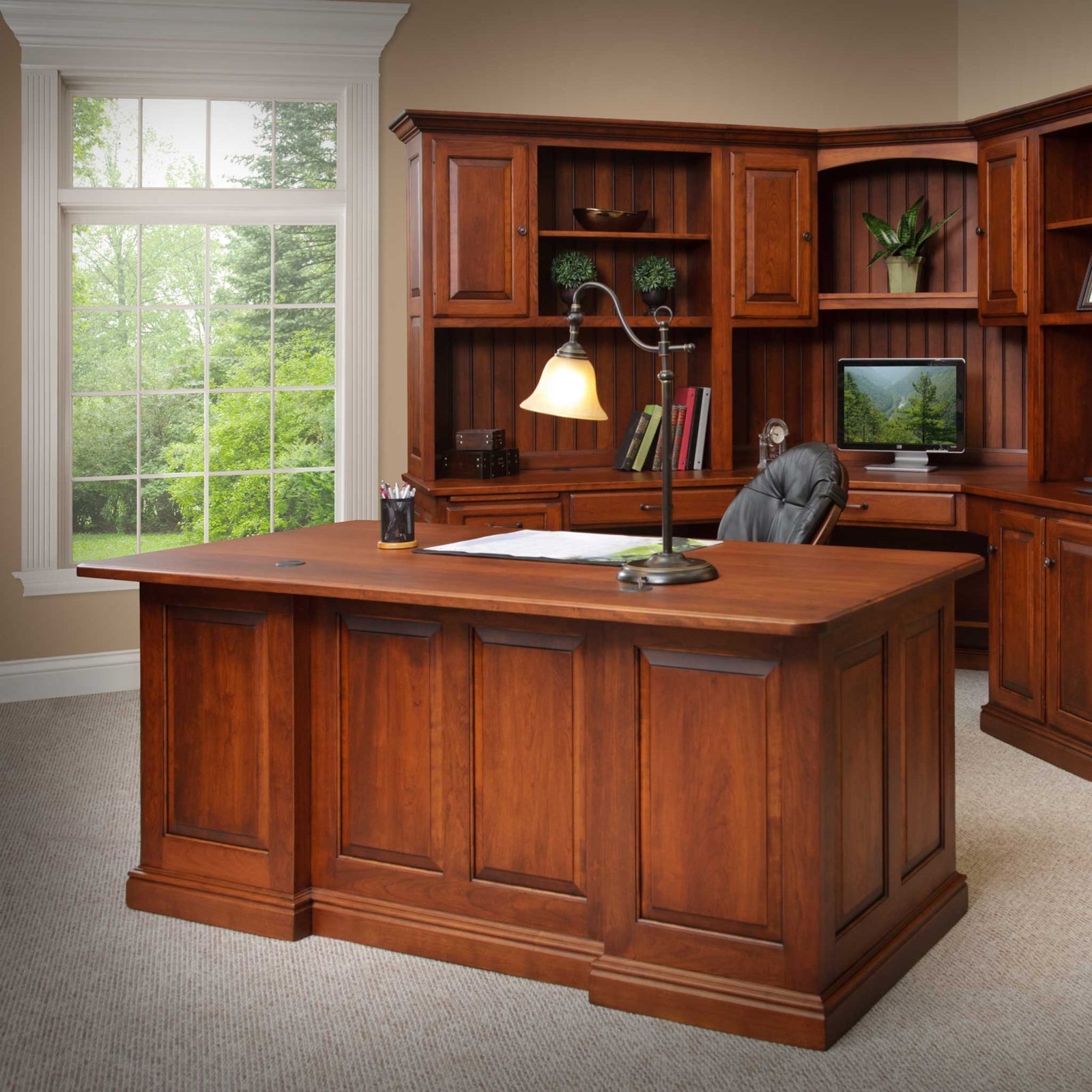 Back of the cherry executive desk showing finished raised panels, two wire grommets and a stepped base