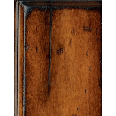 Finish sample close-up of a warm brown distressed panel with worm holes and dark edge accents