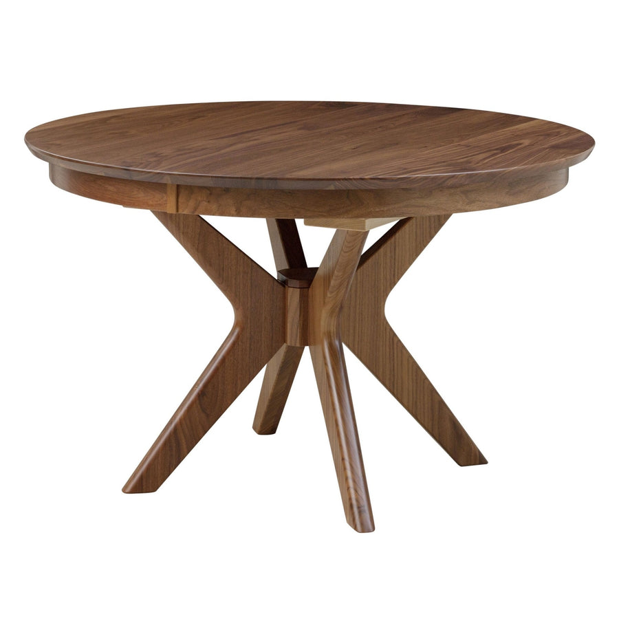 Round expandable walnut pedestal dining table with a crossed angular sculpted base, shown on a white background