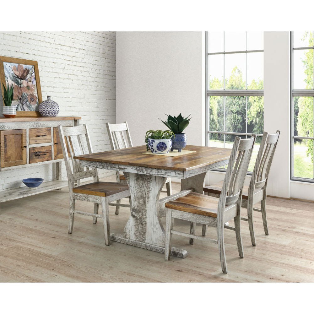 Rustic dining room with a two-tone trestle table, six whitewashed chairs and a distressed sideboard buffet