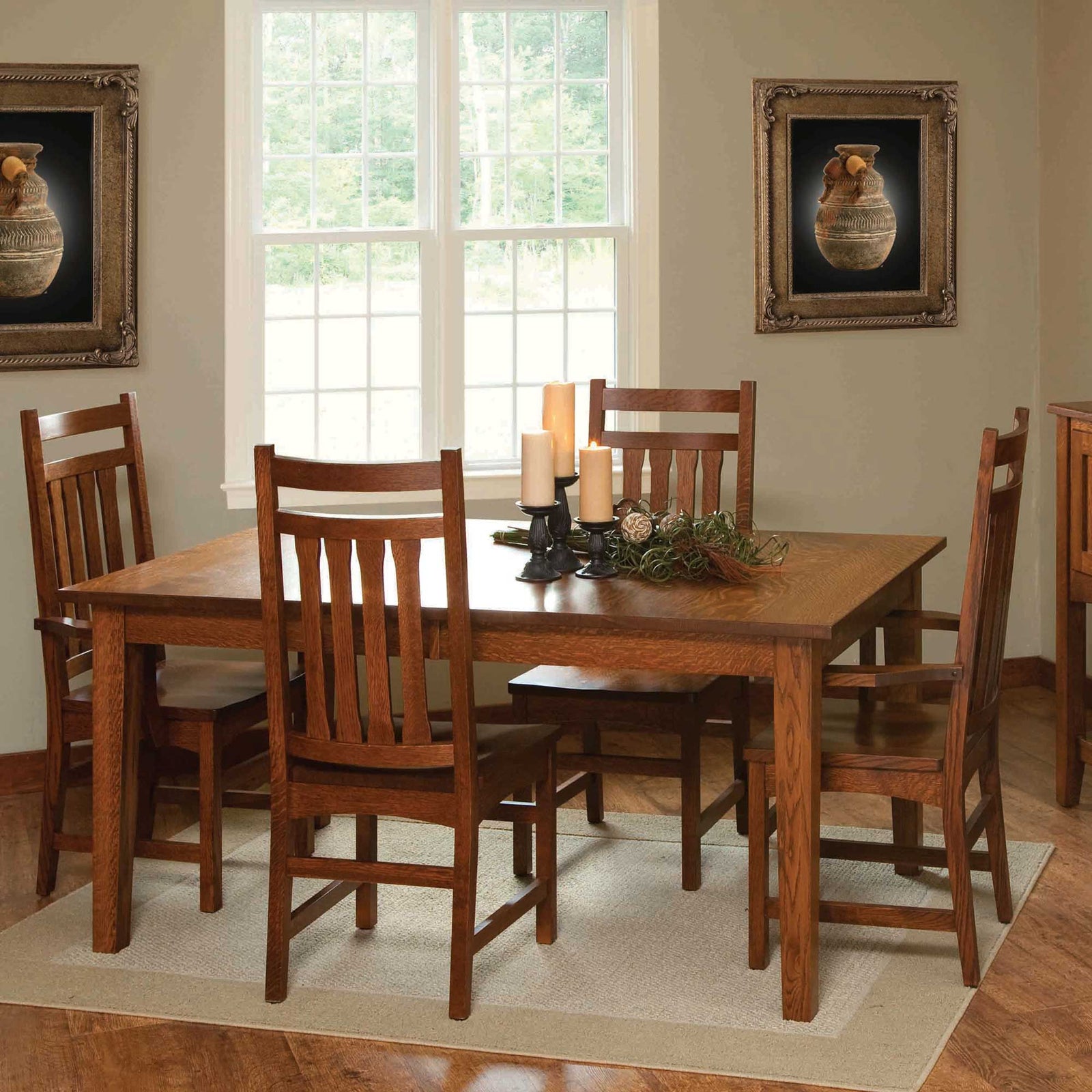 Mission style quartersawn oak leg dining table with slat back chairs, candles and greenery in a sunlit dining room