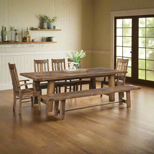 Rustic brown 96 inch iron buckle trestle dining table with bench, slat back chairs and arm chair in a farmhouse dining room
