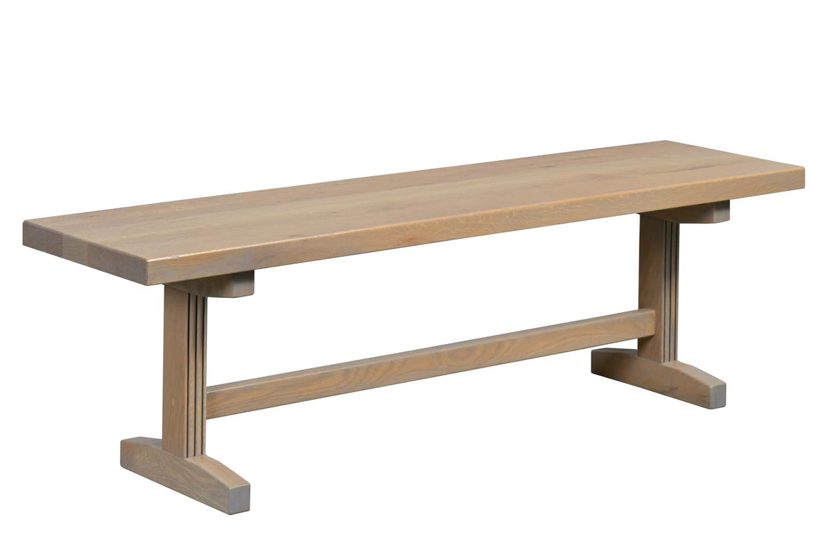 A rustic wooden bench with a natural oak finish, featuring a thick rectangular seat, a central stretcher bar, and angled support legs with square feet, shown against a plain white background.