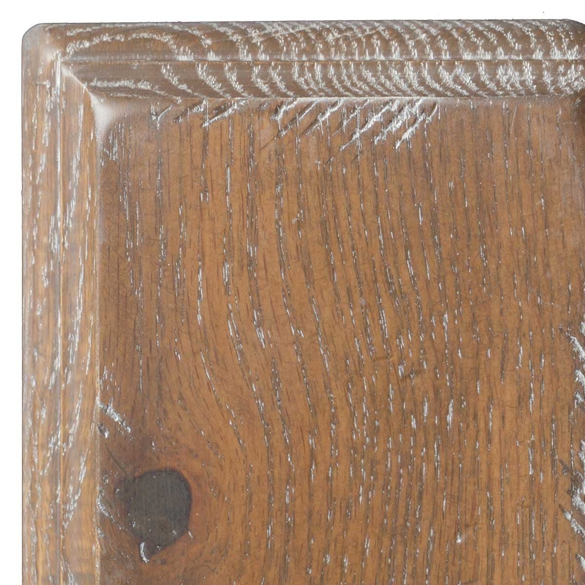 Whitewash Husk on oak, medium brown sample corner with white-limed open grain, a dark knot and beveled molded edge