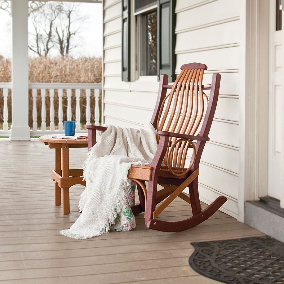 Bentwood style poly porch rocker in cedar and cherry with a throw blanket, beside a small side table
