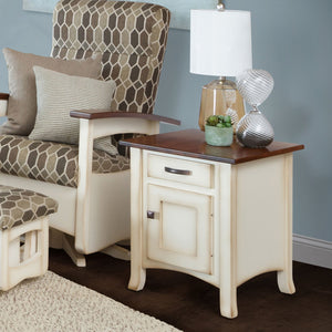 Cream painted enclosed end table with cherry top, one drawer and a cabinet door, styled with a lamp beside a glider