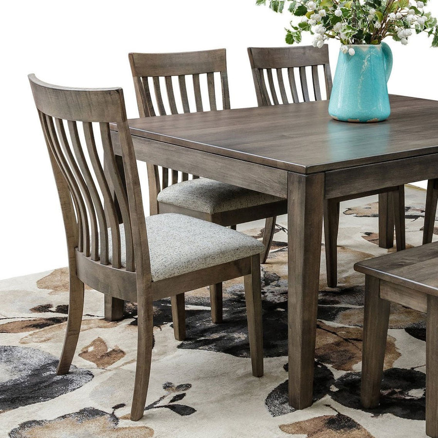 Weathered gray dining side chair with curved vertical back slats and a woven oatmeal upholstered seat by a plank table