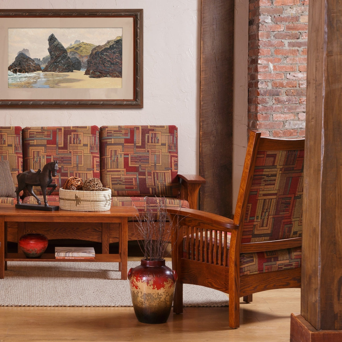 Library chair and matching sofa in geometric fabric with oak frames beside a coffee table and brick column