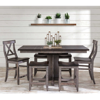 Dark gray gathering table with butcher block style top, X back chairs and saddle counter stools by shiplap wall