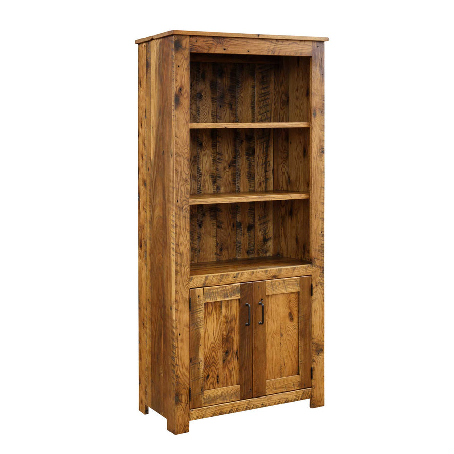 Barnwood bookcase with doors, three adjustable shelves and paneled lower cabinet with black bar pulls on a white background