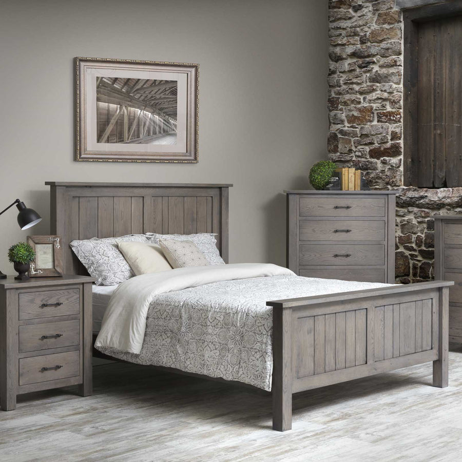 Weathered gray queen panel bed with vertical plank headboard and footboard, flanked by a nightstand and chest of drawers