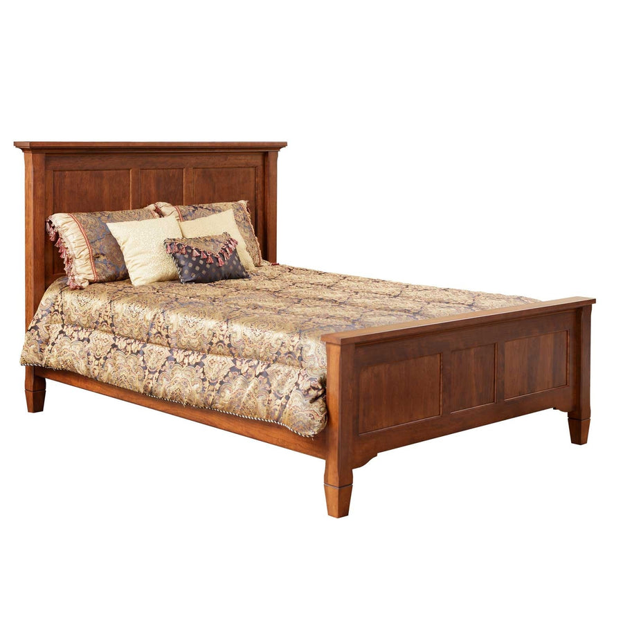 Cherry panel bed with a three-panel headboard and low footboard dressed in gold paisley bedding, white background