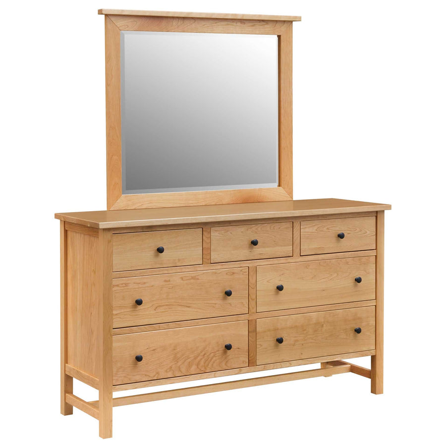 Natural cherry framed mirror standing on the matching seven-drawer dresser with black knobs, on a white background