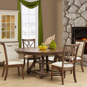 Round expandable dining table in a rustic brown finish with a curved trestle base and four upholstered chairs