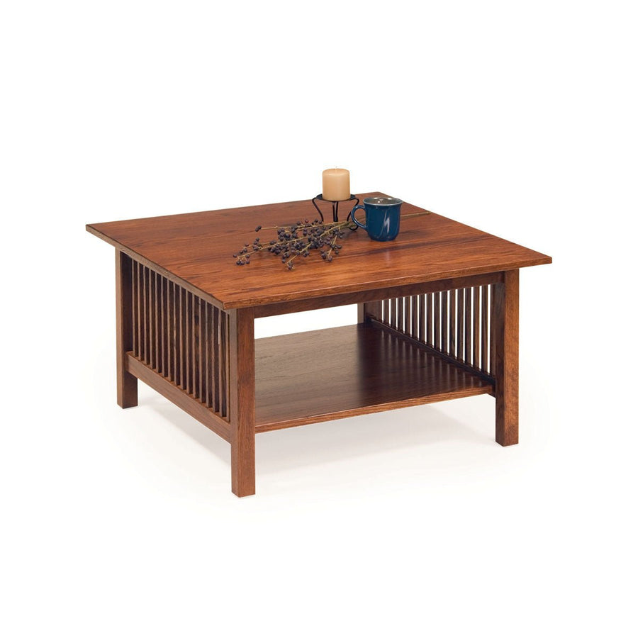 Square oak Mission coffee table with slat sides and a lower shelf, candle and blue mug on the top