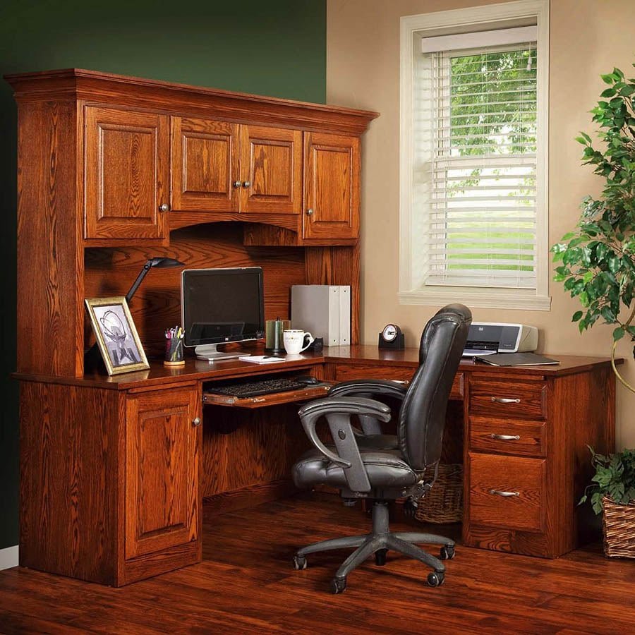 Corner desk workstation in oak with hutch cabinets, task lamp, printer and a gray office chair on a wood floor