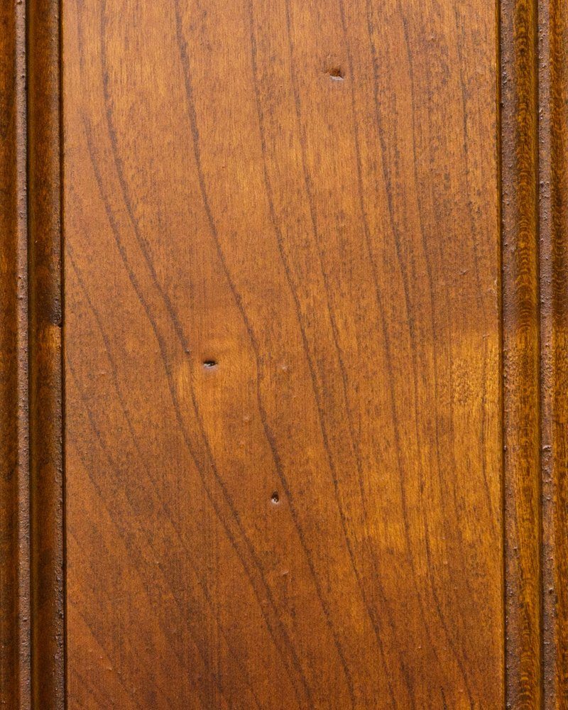 Russet Heritage stain on cherry, a warm golden brown panel with curved grain and worm hole marks