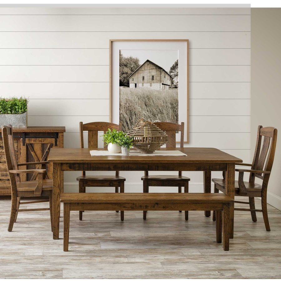 Rustic oak extendable leg dining table with matching bench, chairs and barn door sideboard beneath a framed barn photo