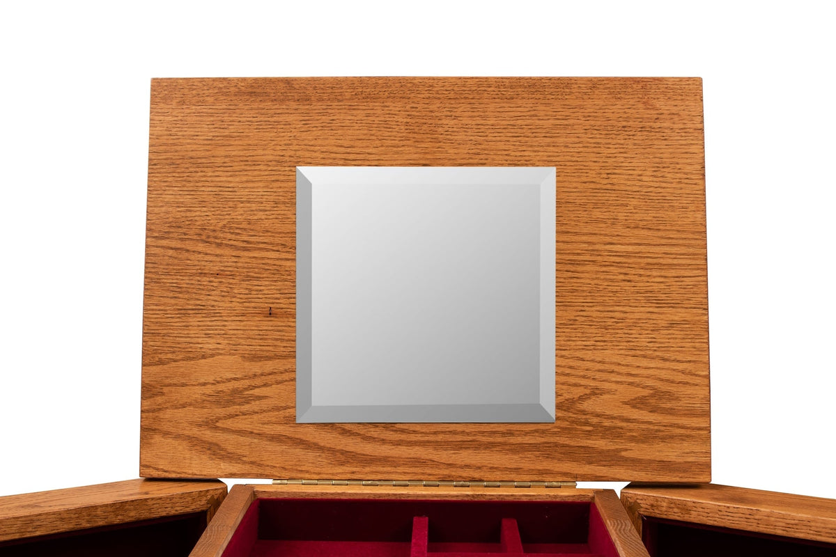Close up of the jewelry armoire lift lid with a beveled square mirror above the red velvet lined tray