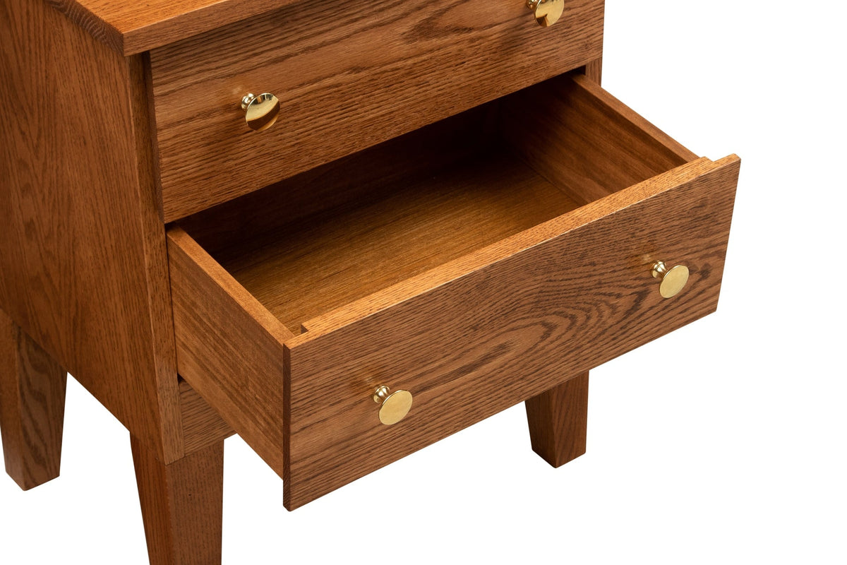 Detail of an open lower drawer on an oak jewelry armoire showing dovetailed sides and brass knobs