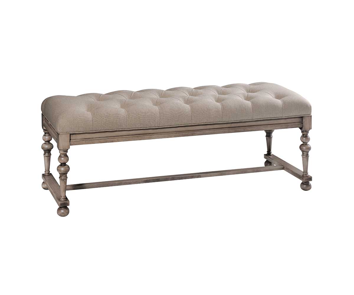 Weathered taupe bed bench upholstered in tufted oatmeal linen with turned legs and a low stretcher rail