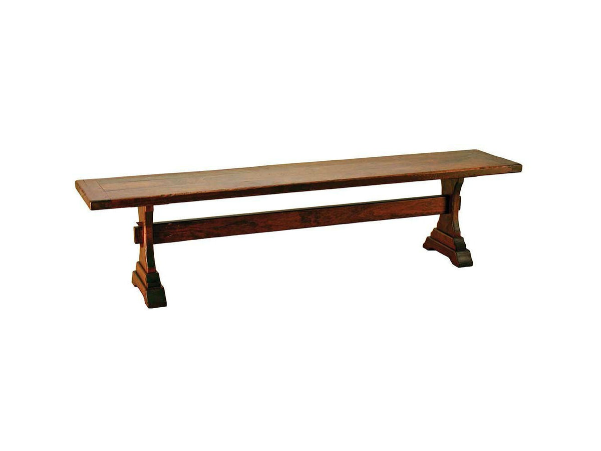 Rustic cherry trestle bench with a plank seat, shaped pedestal legs and a pegged center stretcher