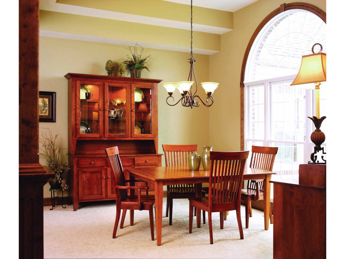 Cherry dining room with a lighted three-door china cabinet, Shaker leg table and slat-back chairs under an iron chandelier