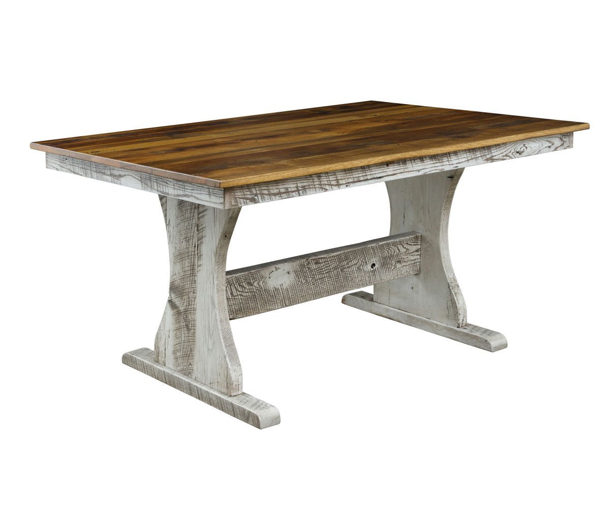 Corner view of a trestle farm table with a warm multi-tone plank top over a distressed whitewashed trestle base