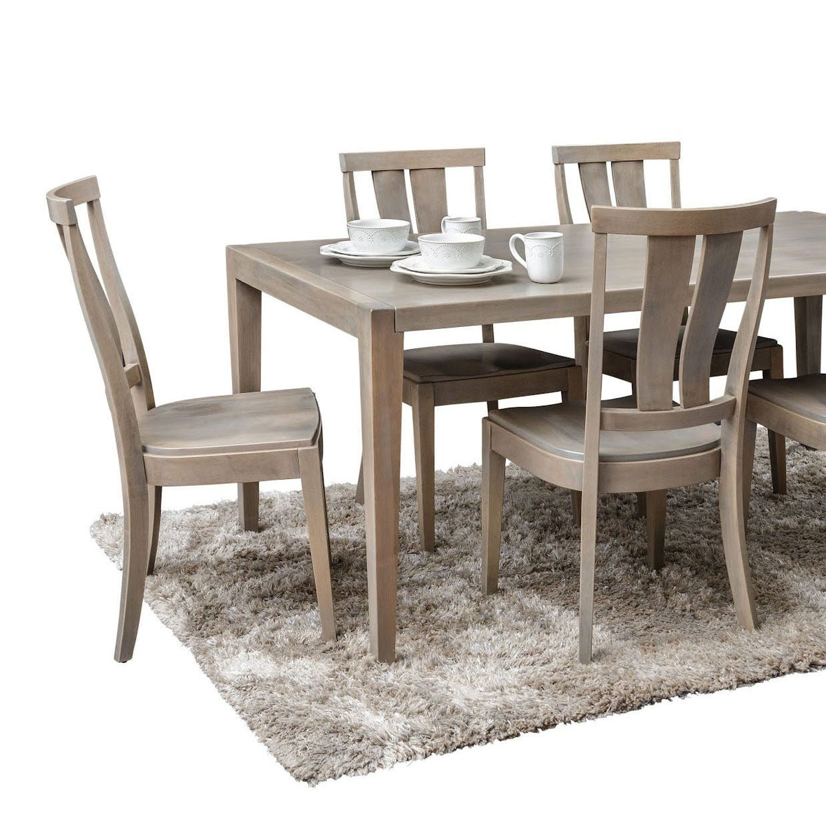 Gray washed rectangular dining table with matching splat back chairs and white teacups on a shag rug