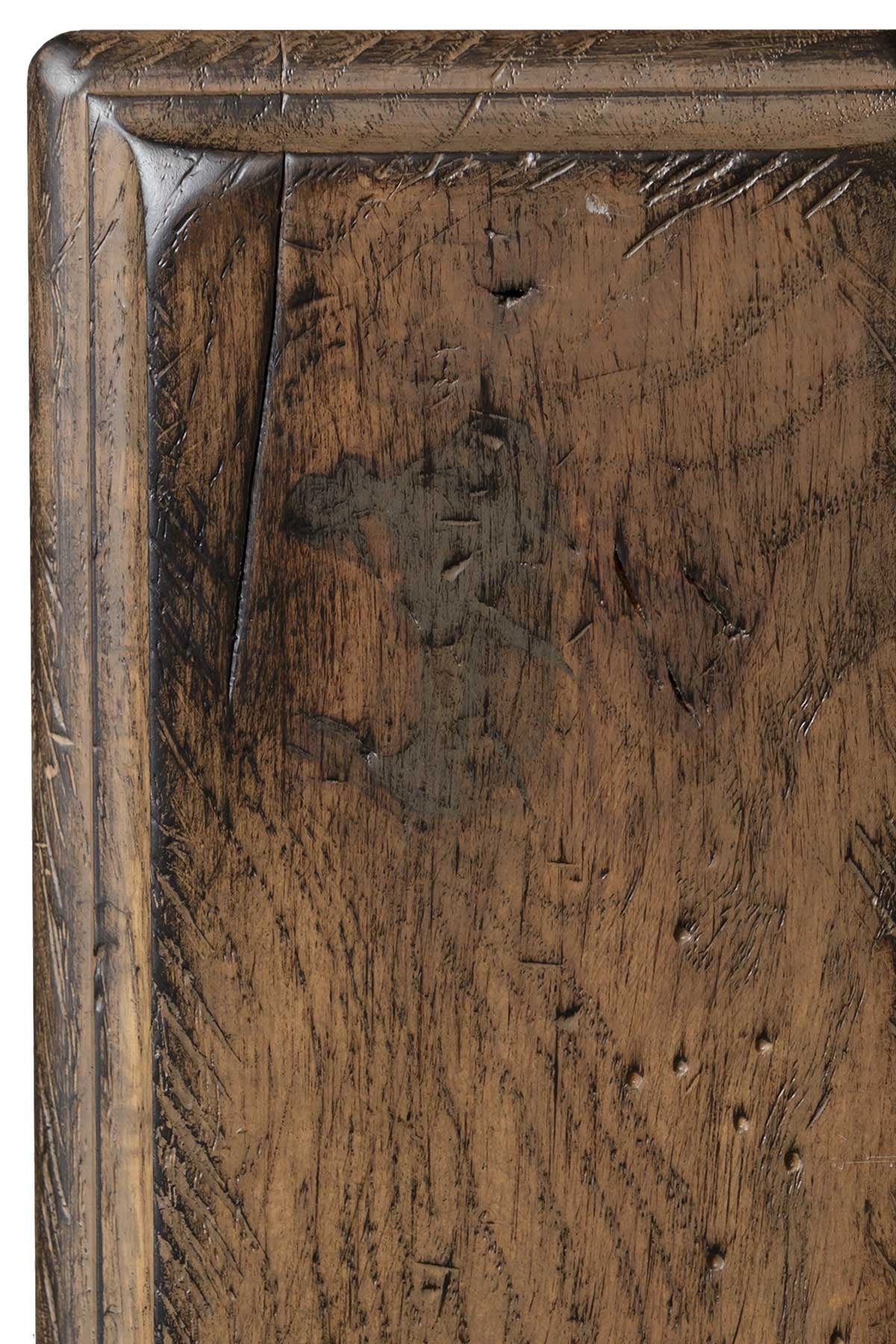 Antiquated Husk on oak, a mellow medium brown sample panel with dense chisel distressing, worm holes and darker molded edges