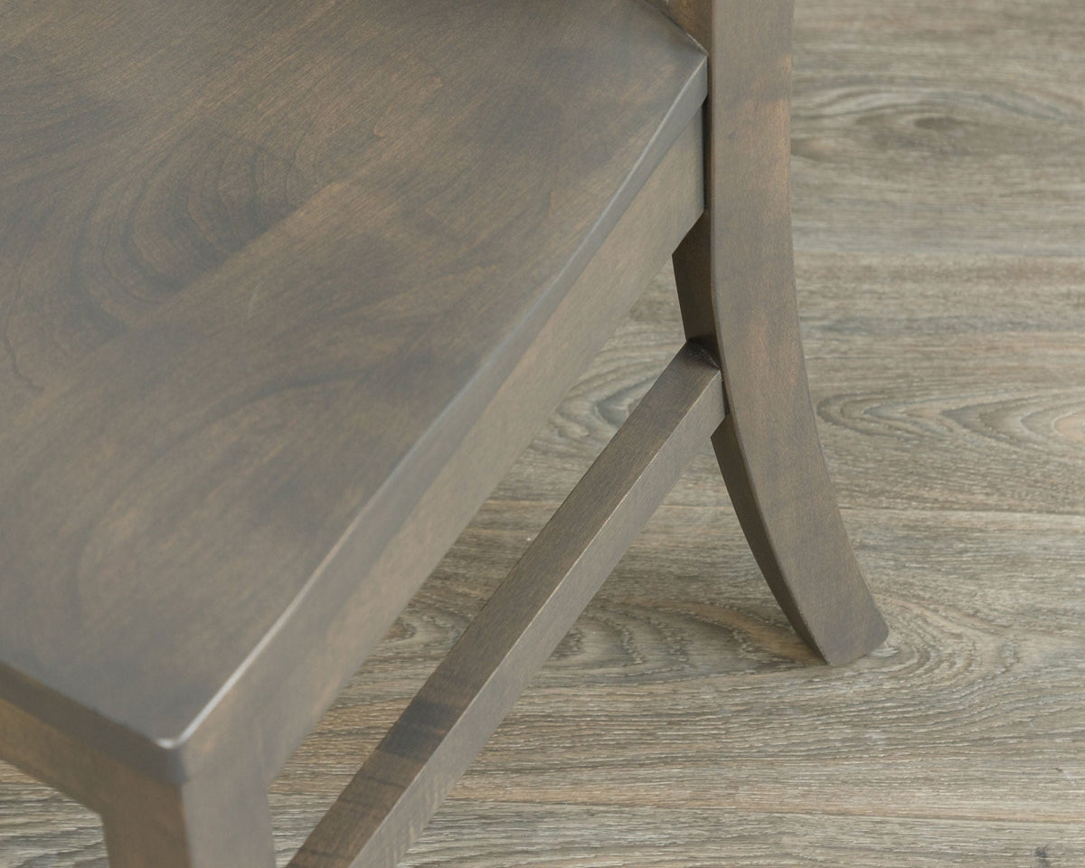 Detail of the gray lumbar chair seat corner showing the contoured wood seat edge, apron and side stretcher