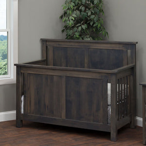 Weathered gray Bloomington crib with flat raised panel ends and slatted sides in a bright corner nursery