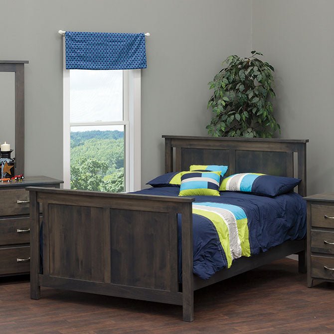 Gray panel full size bed converted from the crib, dressed in navy and lime bedding beside a window