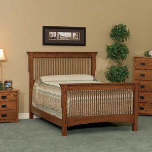 Oak Mission spindle bed with slat headboard and footboard styled in a bedroom with a framed print and plant