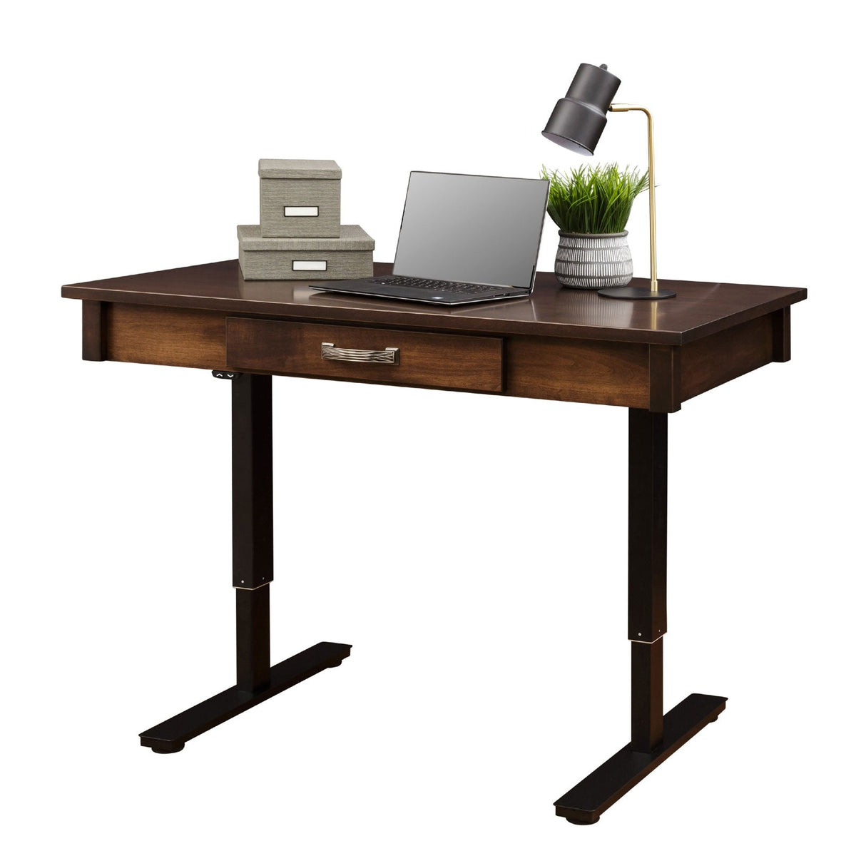 Lift desk staged with a laptop, storage boxes and a lamp on its wood top over black height-adjustable legs