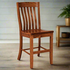 Oak lumbar back bar chair with vertical slats and a saddle seat, footrest rails and a potted plant behind