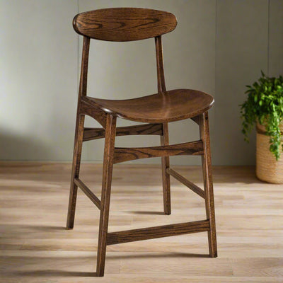 Mid century modern counter stool in dark oak with an oval floating back, saddle seat and angled legs